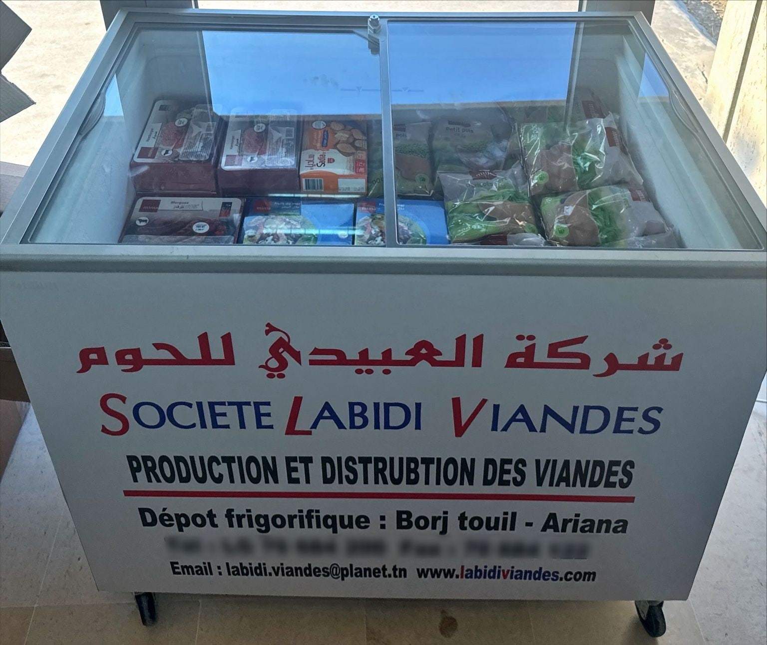 مجمّد بألوان شركة العبيدي للحوم مليء بالمنتجات المجمّدة في محلّ تجاري